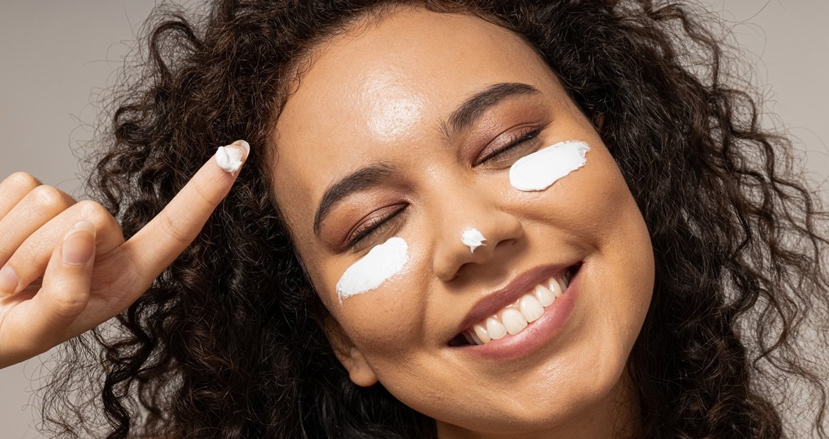 Moça negra aplica produto que pode conter ácido glicólico com outros ativos